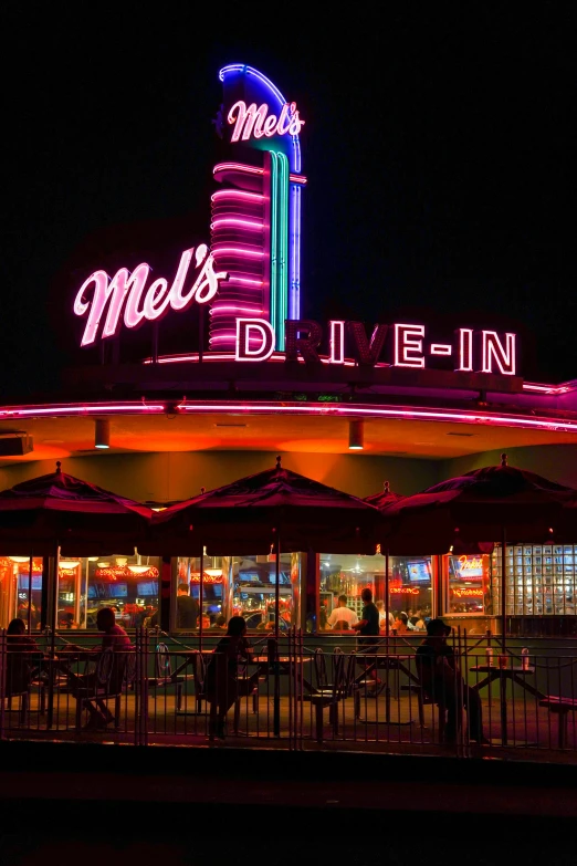 people are eating in a neon lit restaurant