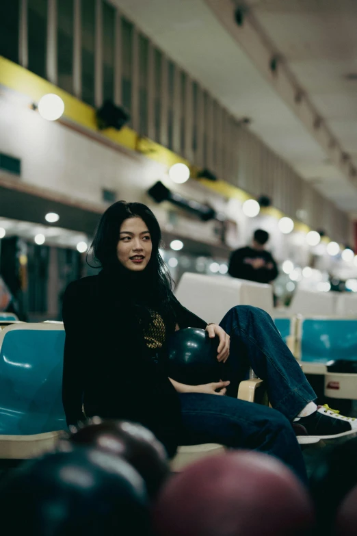 a woman is holding a bowling ball while posing for the camera