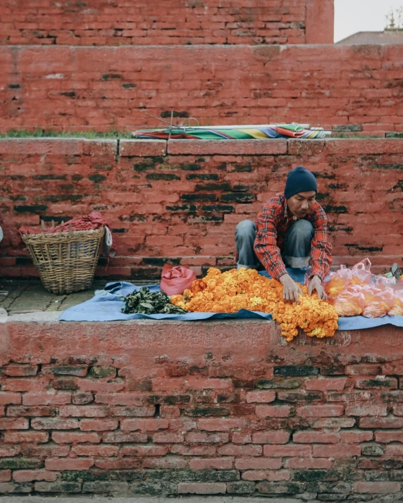 a person sitting down with an orange flower in hand