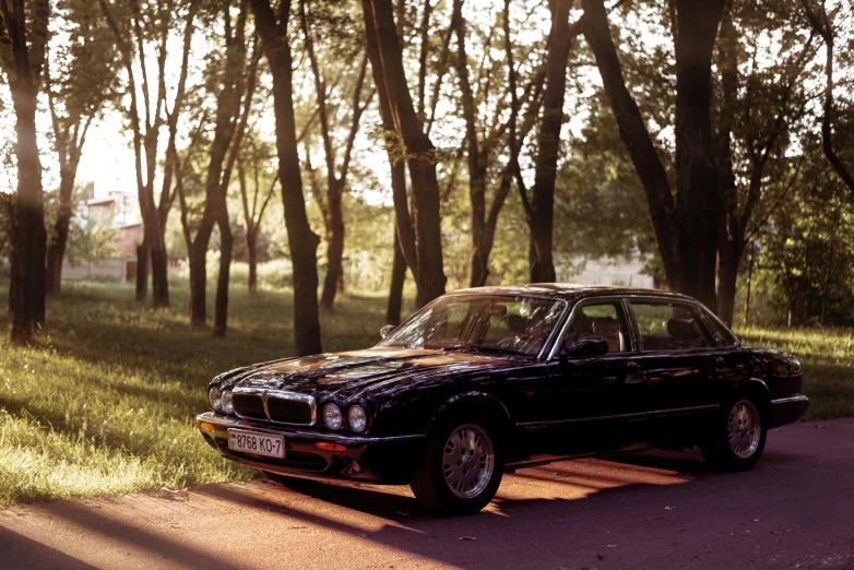 a car parked on the side of a road near trees