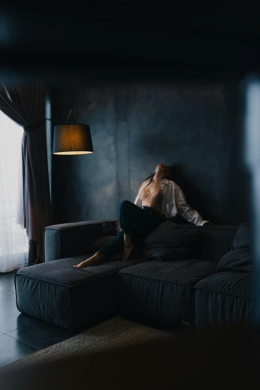 a woman sitting on a couch by a window