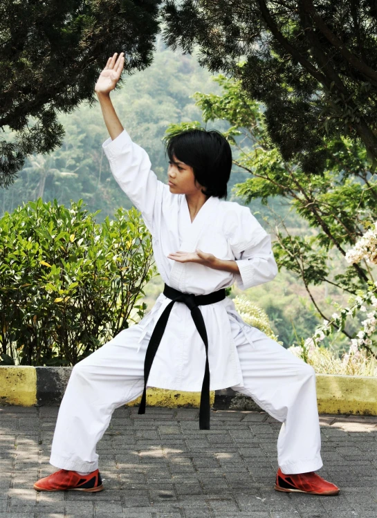 a woman in karate gear is doing a move