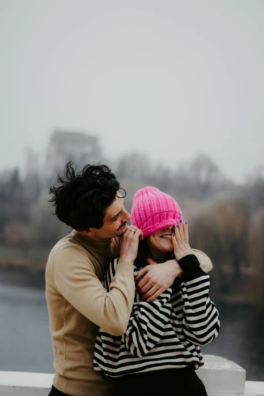 a couple sitting near a river on a bridge