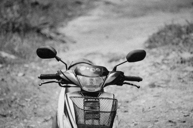 black and white pograph of motorcycle parked on dirt road