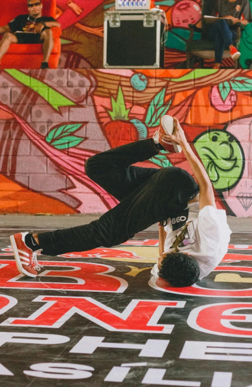 a young man performs a handstand on his skateboard at a skate park