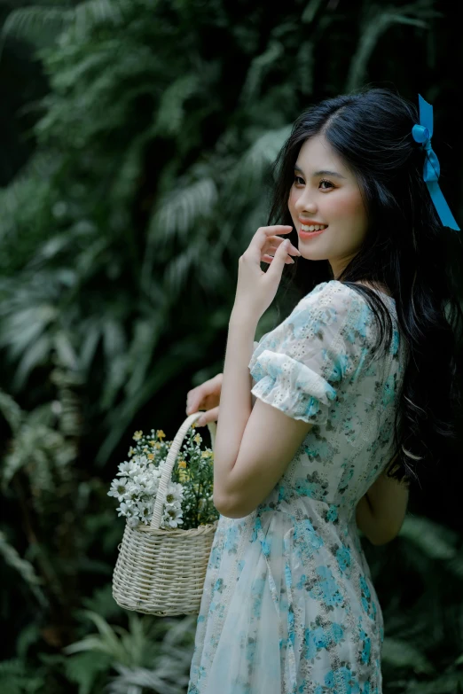 a woman wearing a dress is on the phone and has a basket