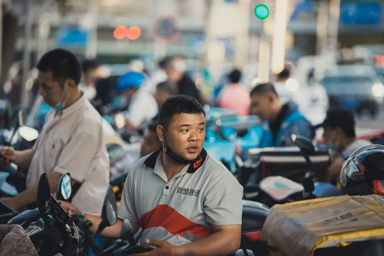 a man riding a motorcycle down a street next to a crowd