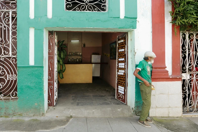 the man is standing outside of the colorful building