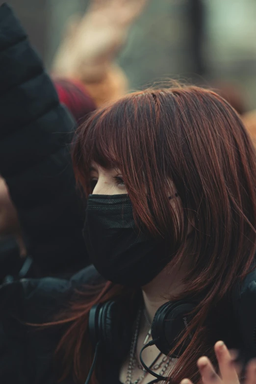 the woman has red hair and wears a black mask
