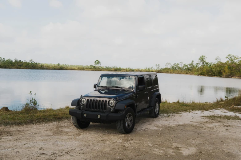 a jeep parked on the side of the road near water