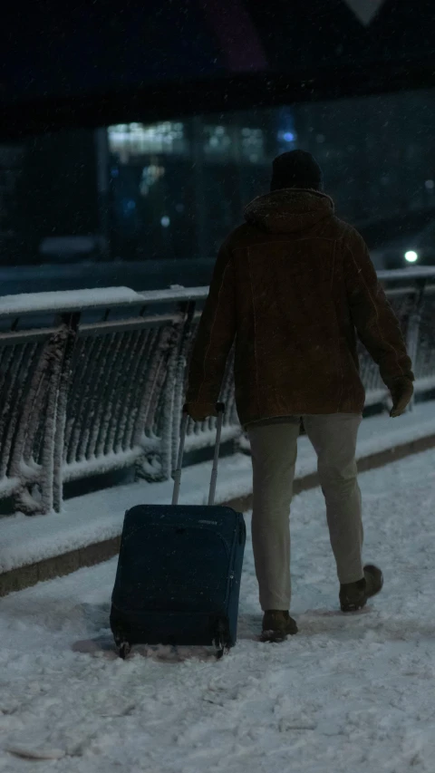 the man is pulling a suitcase across the snow