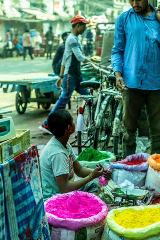 a man talking on his cellphone surrounded by colorful rice