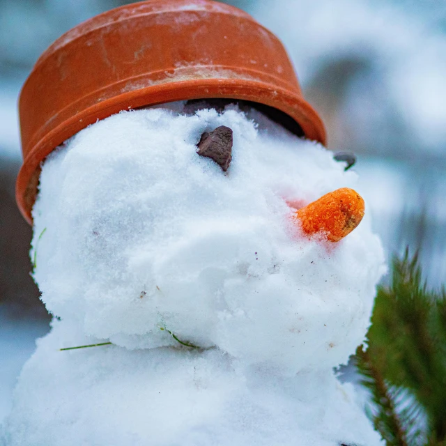 a snowman with a red hat is standing in the snow