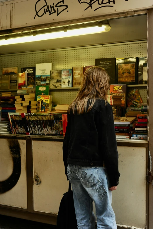 a woman stands at the front of a shop as she looks out