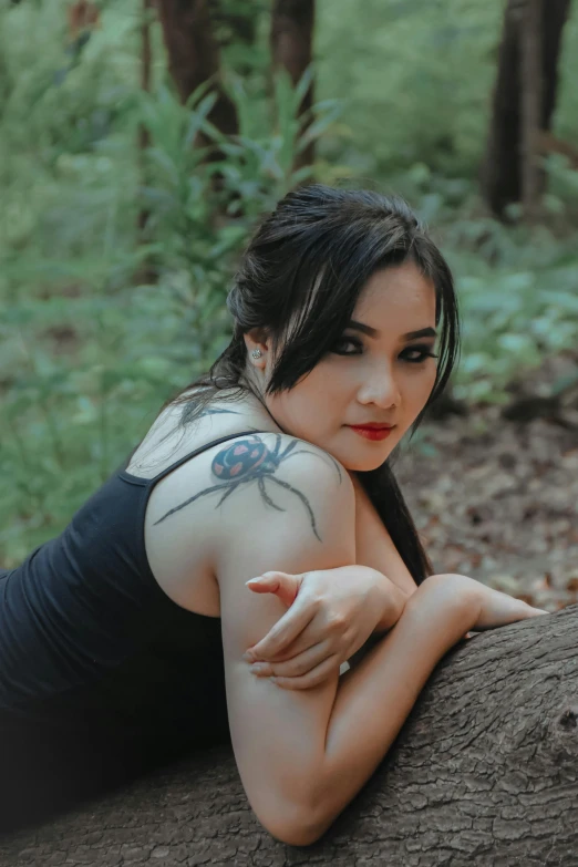 a woman wearing a spider tattoo posing for the camera