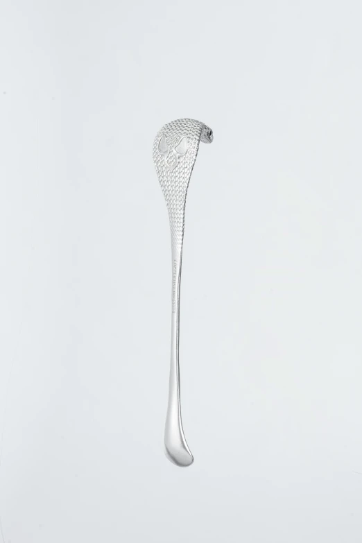 a tall silver spoon is suspended from a long wire