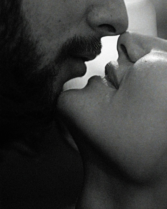 a man kissing a woman who is holding her baby