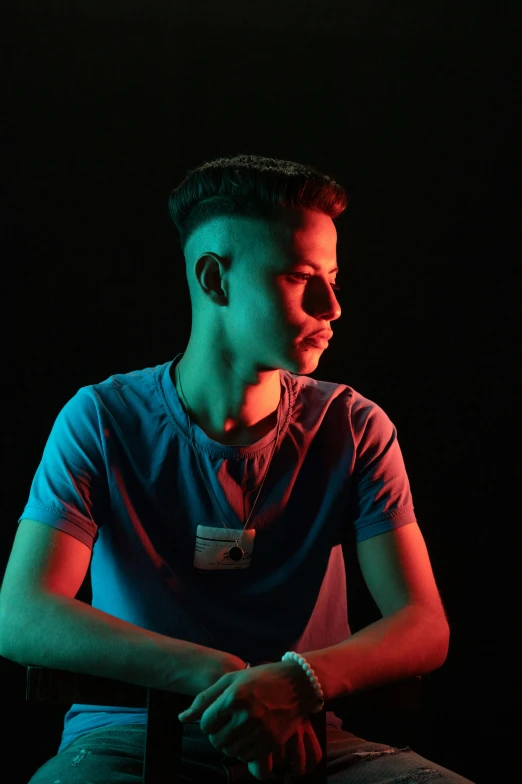 a man sitting on a stool in the dark