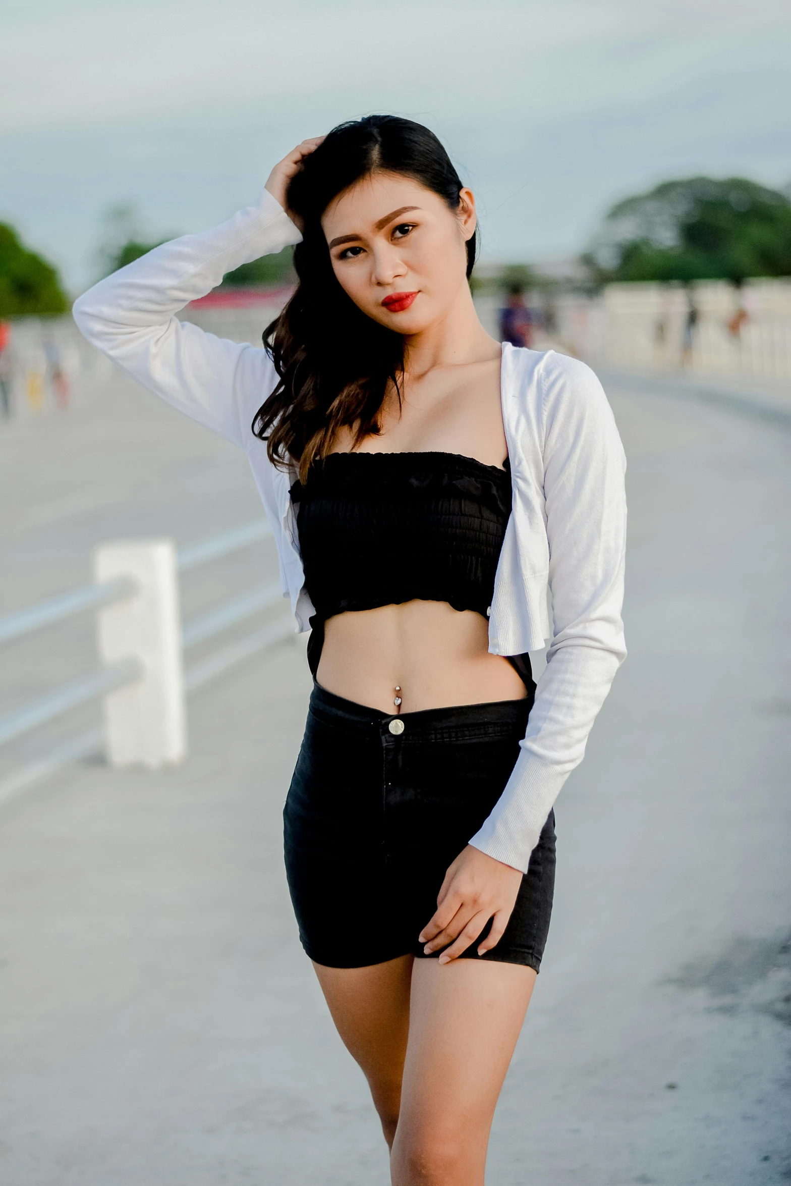 a woman in short black shorts and a white cardigan top