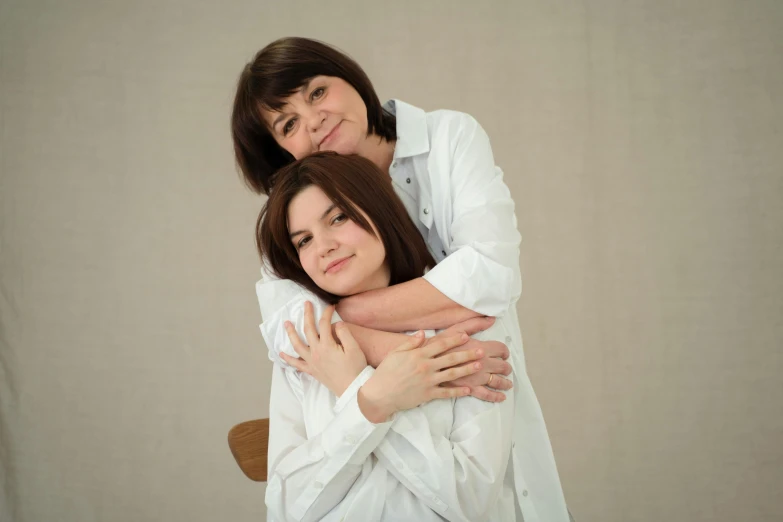 a woman with her arms around another women face