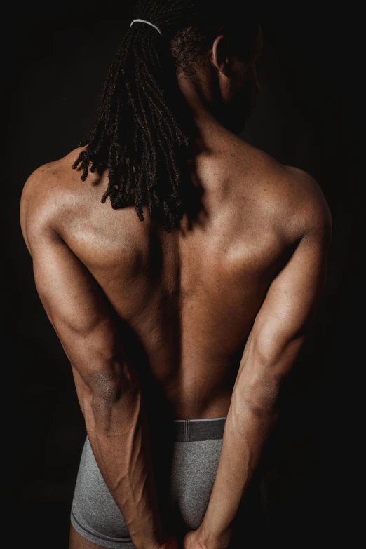 an afro american man with a beard wearing briefs and showing his torso