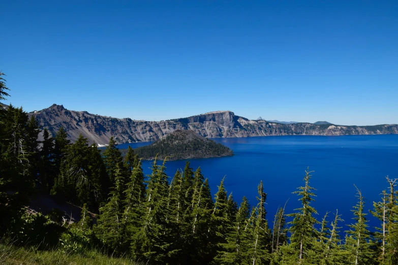 the mountains are close to the large blue lake