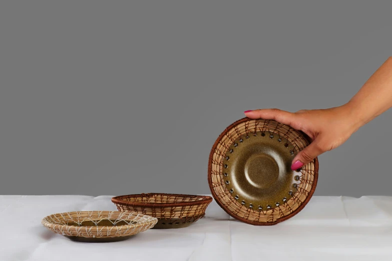 two handmade bowls with a hand holding one with a bowl in the middle and two in the background