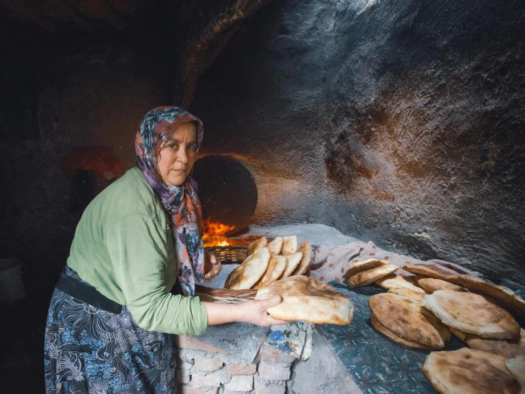 there is a woman holding plates of bread on the table