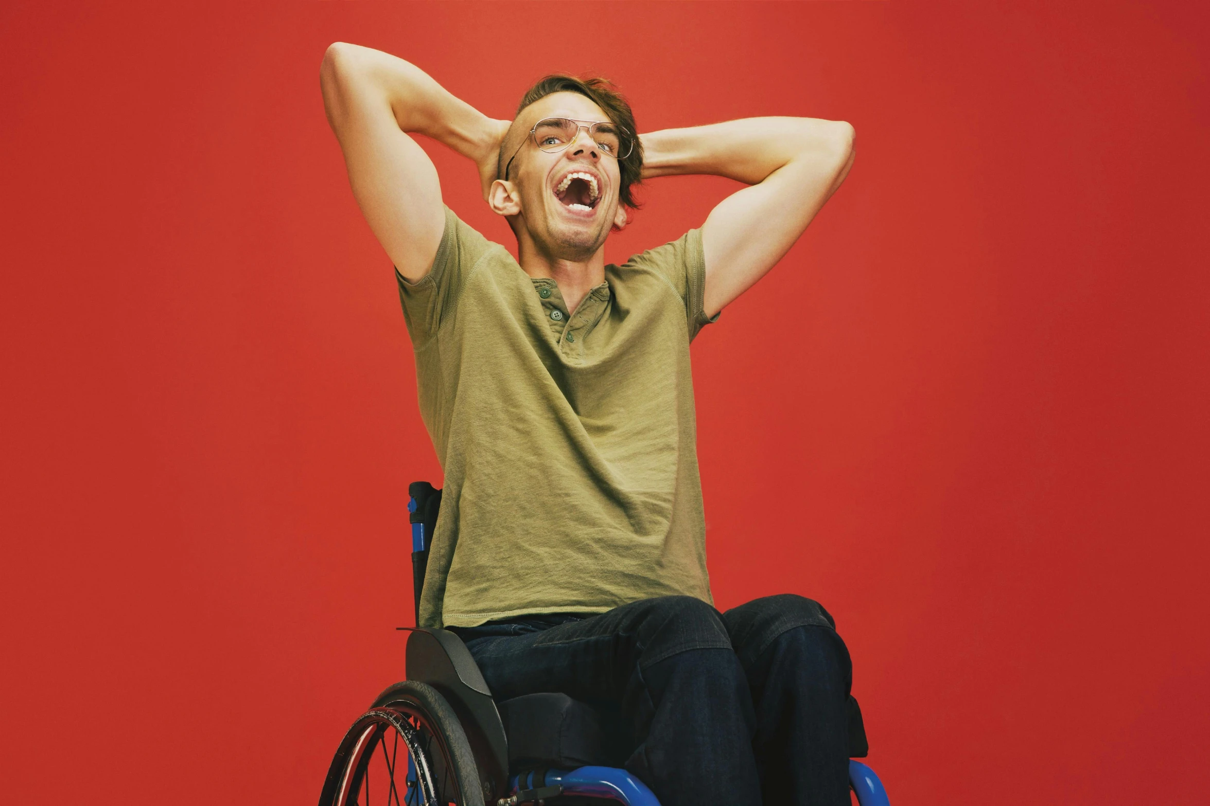 a man in a wheelchair holding his head with his hands and wearing headphones