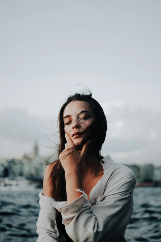 a woman with white makeup holding her chin looking at the camera