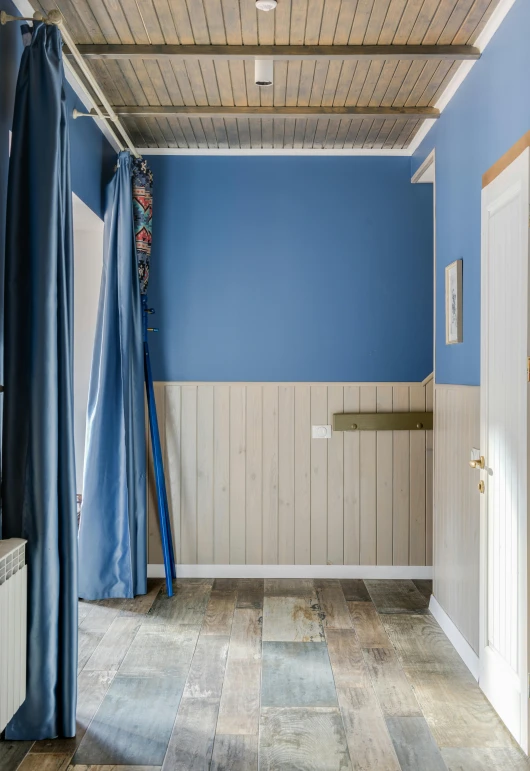 blue and white room with wood paneling on the walls