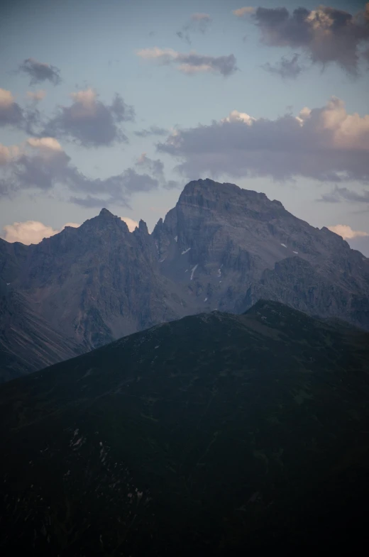 a very tall mountain with clouds on it