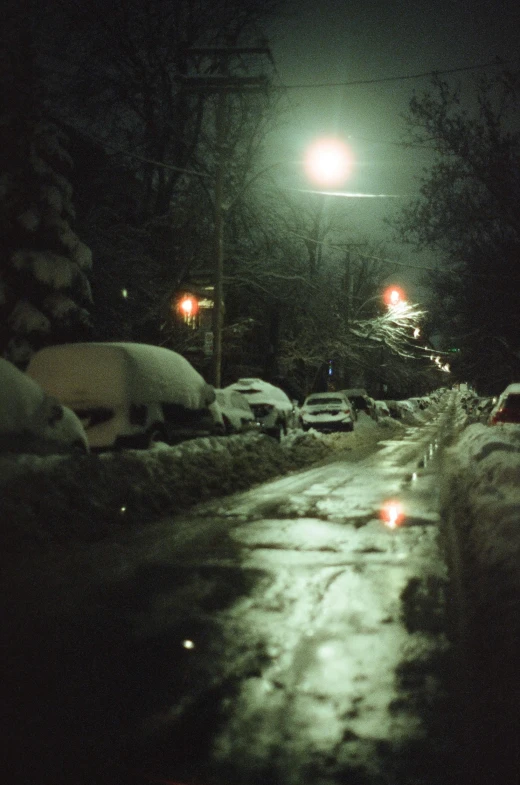 some lights a street snow cars and some cars