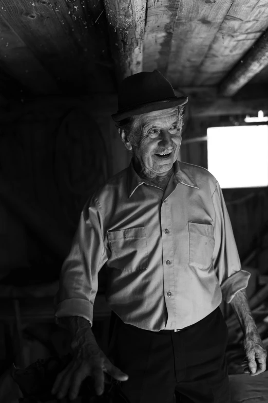 an elderly man standing next to some wood planks