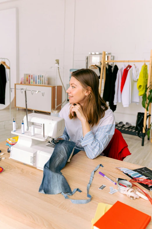 a woman is sewing on a table at a craft shop