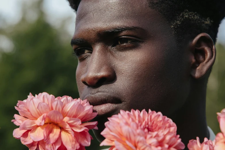 man with pink flowers in his hands
