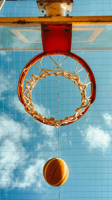 a close up of a basketball going through the rim