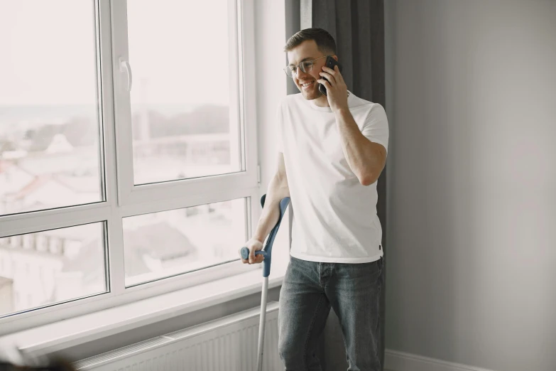 man in white shirt standing next to window with luggage