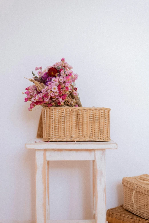 a basket of flowers sits on an old stool