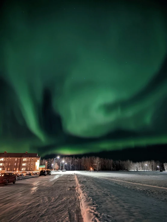 a aurora bore is shining above the snow covered ground