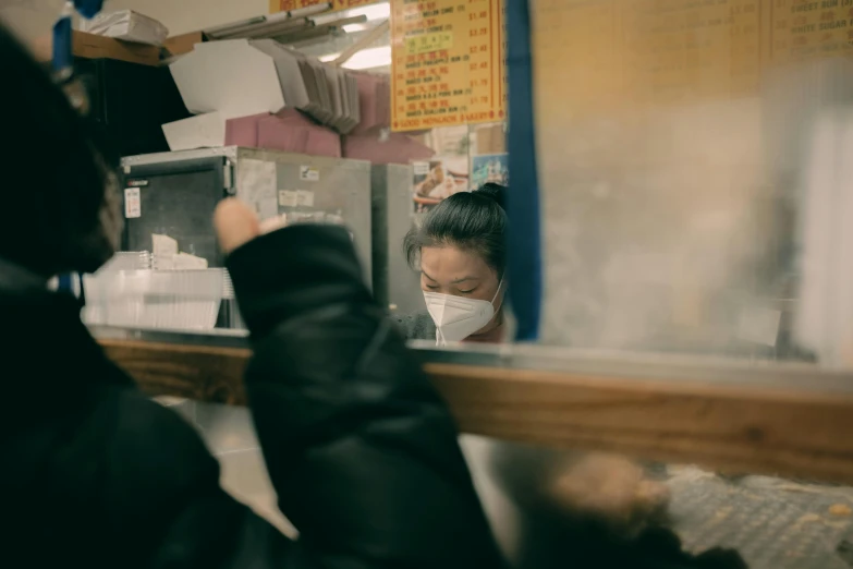 a girl in a mask looks through the window