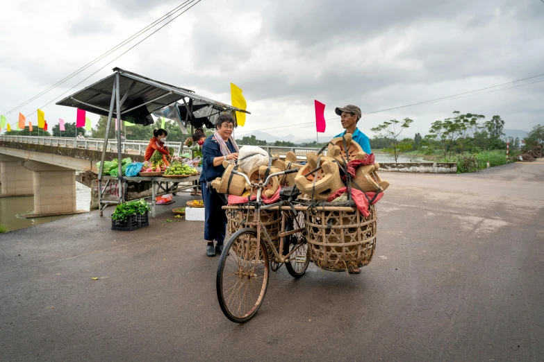 the person in the blue shirt is buying food to the girl on the bicycle