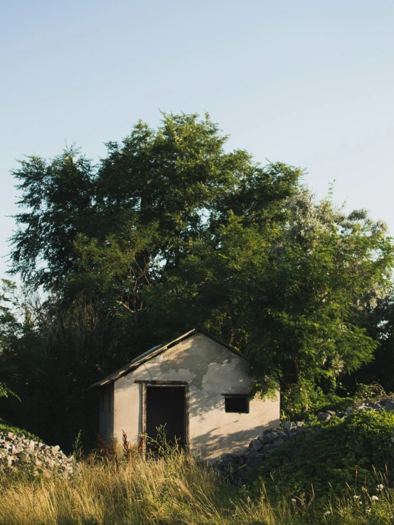 the small shed is on the side of the dirt road