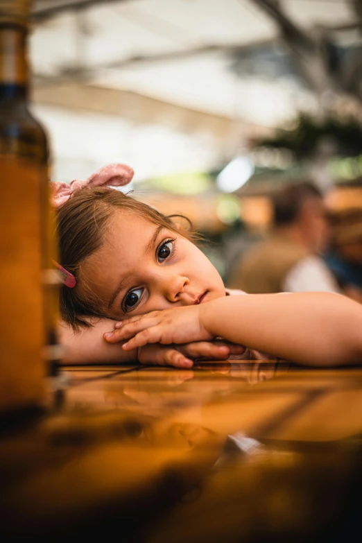 little girl with pink bunny ears laying on her stomach at a restaurant