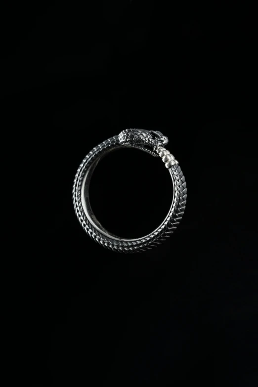 two silver wedding bands are shown against a dark background