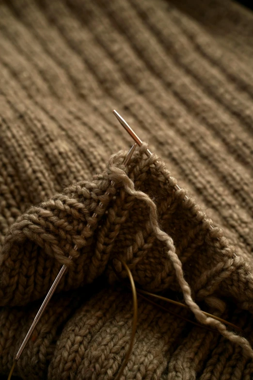 a close up image of a sweaters yarn with needle and needles