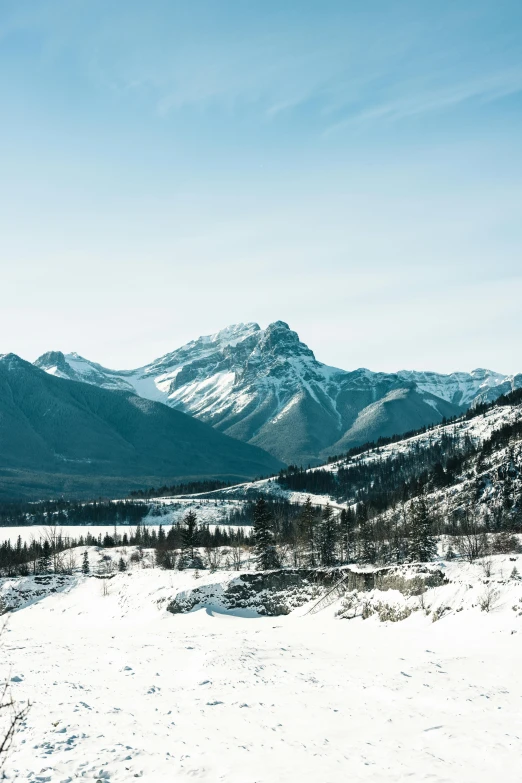 an alpine snow covered plain with mountain range in the background