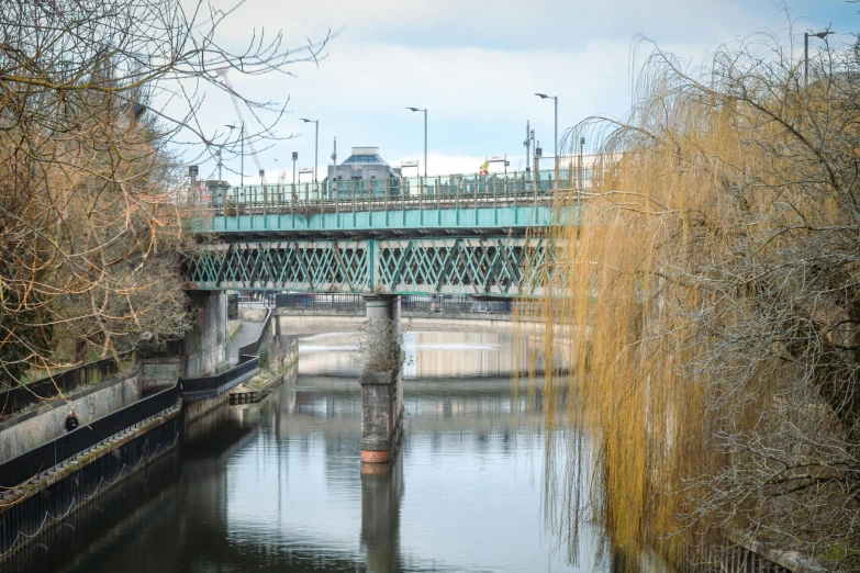 an old train bridge spans over a calm river