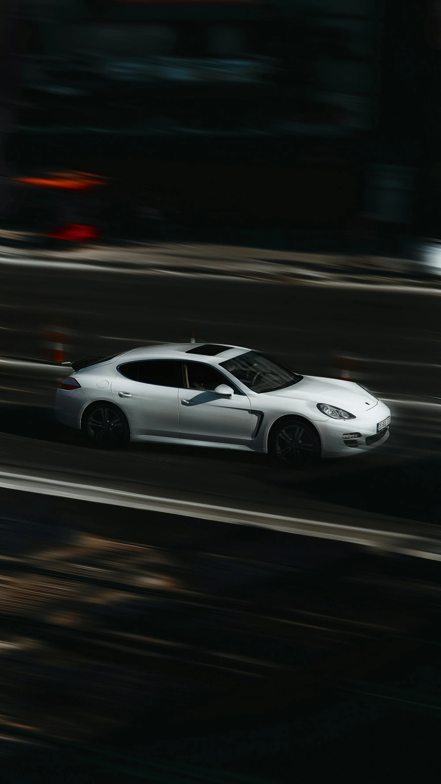 a white sports car driving through the city streets