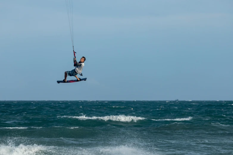 man is kite surfing in the ocean on a windy day